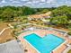 An aerial view shows a sparkling community pool, with lounge chairs and shuffleboard courts at 13618 Niti Dr, Hudson, FL 34669