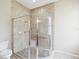 Corner glass enclosed shower with beige tiling, a built-in bench, and tiled floors at 13618 Niti Dr, Hudson, FL 34669