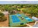 Aerial shot of well-maintained community tennis and pickleball courts surrounded by mature trees at 13618 Niti Dr, Hudson, FL 34669