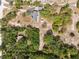 Aerial view of the property showing the house, outbuildings and the extensive tree coverage at 14545 Battenwood Dr, Spring Hill, FL 34610