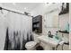 Bathroom with shower featuring a decorative curtain, with pedestal sink, and toilet with black storage cabinet at 14545 Battenwood Dr, Spring Hill, FL 34610