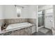 Bright bathroom featuring a soaking tub with tile surround and separate glass-enclosed shower at 14545 Battenwood Dr, Spring Hill, FL 34610