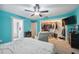Bright bedroom with blue walls, neutral carpet, ceiling fan, walk-in closet and electric fireplace at 14545 Battenwood Dr, Spring Hill, FL 34610