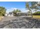 Exterior view of the house showing a large driveway and additional garage/barn on this expansive property at 14545 Battenwood Dr, Spring Hill, FL 34610