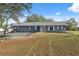 Charming gray house with white trim and a well-manicured lawn in a sunny setting at 14545 Battenwood Dr, Spring Hill, FL 34610