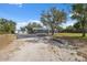 Gray house with a matching detached garage, surrounded by mature trees at 14545 Battenwood Dr, Spring Hill, FL 34610
