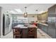 Modern kitchen with gray cabinets, granite island, stainless steel appliances, and a skylight at 14545 Battenwood Dr, Spring Hill, FL 34610