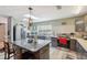 Modern kitchen with gray cabinets, granite island, stainless steel appliances, and a skylight at 14545 Battenwood Dr, Spring Hill, FL 34610