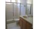 Bathroom features a tiled shower with glass doors, vanity with wood cabinetry and a cream sink at 1514 Citrine Trl, Tarpon Springs, FL 34689