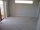 Spacious bedroom with neutral carpet, and a large window providing natural light at 1514 Citrine Trl, Tarpon Springs, FL 34689