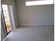Bright bedroom with sliding glass doors that lead to a balcony with carpeted floors and natural light at 1514 Citrine Trl, Tarpon Springs, FL 34689