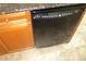 The image is a close up of the black dishwasher and wood cabinet at 1514 Citrine Trl, Tarpon Springs, FL 34689