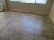 This room features tile flooring, neutral walls and baseboards, and a large window with vertical blinds at 1514 Citrine Trl, Tarpon Springs, FL 34689
