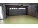 Unfinished basement with large garage door, exposed piping, and concrete walls at 1514 Citrine Trl, Tarpon Springs, FL 34689