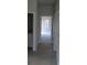 Hallway with neutral carpet leading to a sunlit room, showcasing a bright and airy atmosphere at 1514 Citrine Trl, Tarpon Springs, FL 34689