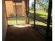 Enclosed lanai area overlooking a grassy backyard and mature landscaping at 1514 Citrine Trl, Tarpon Springs, FL 34689