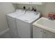 Functional laundry room featuring a washer, dryer, sink, and storage cabinets, maximizing space and convenience at 1514 Citrine Trl, Tarpon Springs, FL 34689