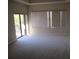 Bright living room that features sliding glass doors to a balcony, blinds, carpeted floors, and natural light at 1514 Citrine Trl, Tarpon Springs, FL 34689