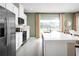 Modern kitchen featuring a large island, stainless appliances, and view to the outdoors at 20334 Lou Angela Ln, Lutz, FL 33558