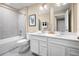 Bright bathroom features a double vanity with white cabinetry and a shower over tub with gray tiling at 20385 Lou Angela Ln, Lutz, FL 33558