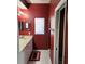This bathroom features a double sink, red accent wall, and a tiled floor at 21008 Sunpoint Way # 204, Lutz, FL 33558