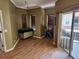 Living room with hardwood floors, olive tone walls, wood blinds, and sliding door to balcony at 21008 Sunpoint Way # 204, Lutz, FL 33558