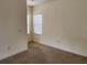 Bright bedroom with neutral paint, carpet, and a window providing natural light at 21041 Sunpoint Way # 202, Lutz, FL 33558