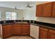 Well-equipped kitchen with wood cabinets, a black countertop, and stainless steel appliances at 21041 Sunpoint Way # 202, Lutz, FL 33558