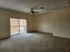 Spacious living room featuring sliding glass doors, carpet floors, and a ceiling fan at 21041 Sunpoint Way # 202, Lutz, FL 33558