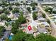 Expansive aerial view of a neighborhood featuring mature trees, well-maintained homes, and proximity to a commercial area at 2660 Orangewood Ct, Palm Harbor, FL 34684