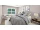 Comfortable bedroom featuring a large window, chair, neutral walls and plush bedding at 2660 Orangewood Ct, Palm Harbor, FL 34684