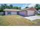 Charming single-Gathering home features a two-car garage with stone accents and a well-manicured front lawn at 2660 Orangewood Ct, Palm Harbor, FL 34684