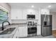 Updated kitchen featuring white cabinetry, granite countertops and stainless steel appliances at 2660 Orangewood Ct, Palm Harbor, FL 34684