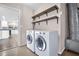 Modern laundry area with washer, dryer, and floating shelves at 2660 Orangewood Ct, Palm Harbor, FL 34684