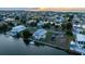 Waterfront property featuring a private dock, expansive lawn, and lush landscaping at sunset at 3340 Oleander Dr, Hernando Beach, FL 34607