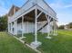 Elevated two-story home exterior on a spacious lot, featuring sturdy support beams and a large yard at 3340 Oleander Dr, Hernando Beach, FL 34607