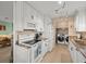 Modern kitchen with white cabinetry, stainless steel appliances, and adjacent laundry area at 3340 Oleander Dr, Hernando Beach, FL 34607