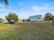 A spacious front yard with green grass, agility training equipment, parked car, and a charming house nearby at 3340 Oleander, Hernando Beach, FL 34607