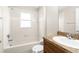 Bathroom featuring a tub with white tile surround and a vanity with a granite-look countertop at 3410 Thistledown Ln, Land O Lakes, FL 34638