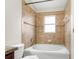Bright bathroom showcases a tub and shower combination with decorative brown tile at 3410 Thistledown Ln, Land O Lakes, FL 34638