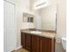 Bathroom vanity featuring a stylish countertop, sink, and wooden cabinets, accompanied by a large mirror and neutral wall colors at 3410 Thistledown Ln, Land O Lakes, FL 34638