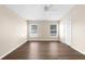 A light and airy bedroom features wood floors, a ceiling fan, closet and natural light from two windows at 3410 Thistledown Ln, Land O Lakes, FL 34638