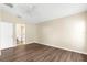 A bedroom with wood floors leads to an ensuite bath with tile floors, a commode, and a shower at 3410 Thistledown Ln, Land O Lakes, FL 34638