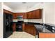 Well-equipped kitchen features black appliances, wood cabinets, granite countertops, and stainless steel sink at 3410 Thistledown Ln, Land O Lakes, FL 34638