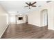 Spacious living room showcasing wood-look flooring, ceiling fan, and breakfast bar with an open layout to kitchen at 3410 Thistledown Ln, Land O Lakes, FL 34638