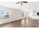 Bright living room featuring an open layout, wood-look flooring, and view of the breakfast bar and kitchen at 3410 Thistledown Ln, Land O Lakes, FL 34638