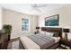 Modern main bedroom features a luxurious bed, wooden floors, stylish furniture, decor, and a ceiling fan at 3410 Thistledown Ln, Land O Lakes, FL 34638