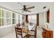 Well-lit dining room with a glass table, ceiling fan, and natural light from surrounding windows at 3638 Bigelow Dr, Holiday, FL 34691