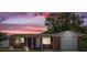 Charming single Gathering home with a brick facade and quaint front porch under a beautiful sunset at 3638 Bigelow Dr, Holiday, FL 34691