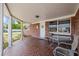 Charming red brick front porch with tile floor and table set at 3638 Bigelow Dr, Holiday, FL 34691